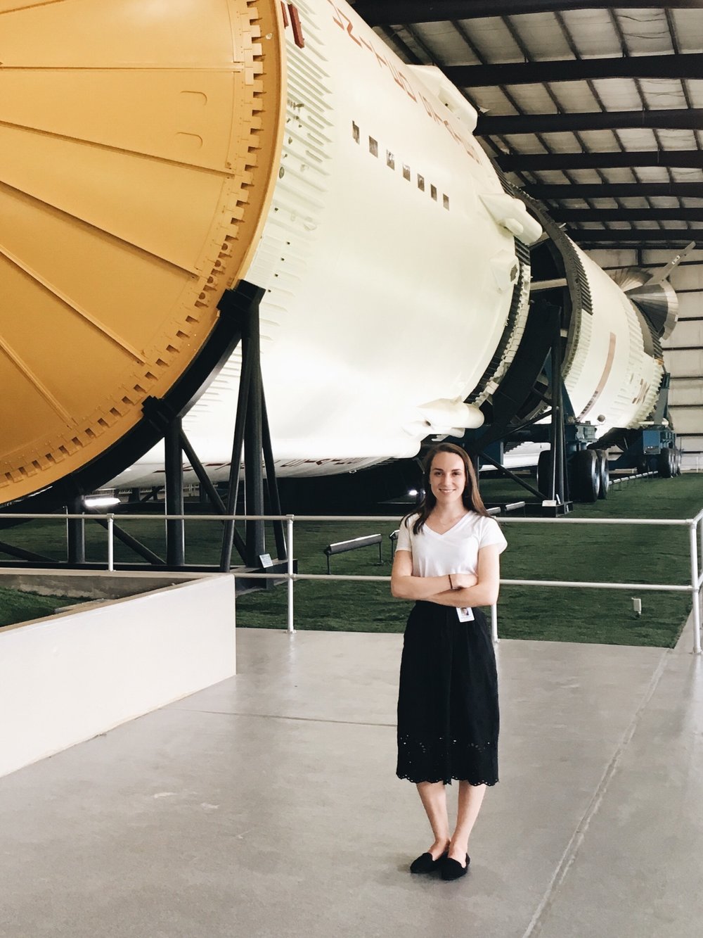 Julia Milton in front of the Saturn V rocket