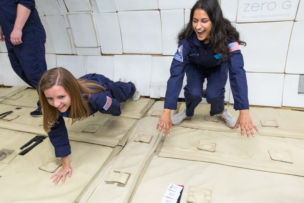 Becca Browder (l) does a one-armed push-up while helping Media Lab's Mehak Sarang with an experiment aboard a lunar gravity flight. Photo: Steve Boxall/ZERO-G