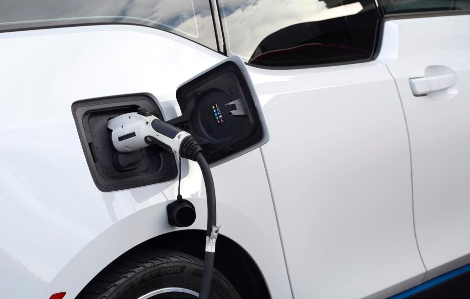 An electric car is plugged in to charge