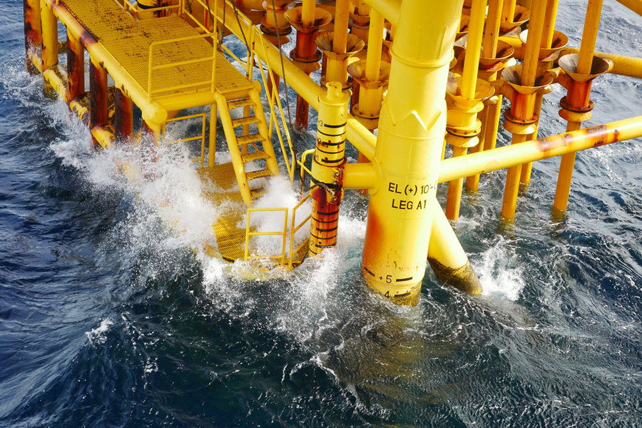 stock photo of waves breaking against an oil platform