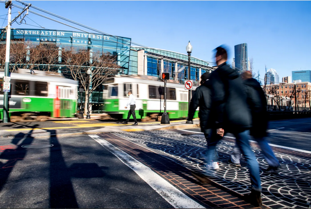 A group crossing the street toward the Green Line