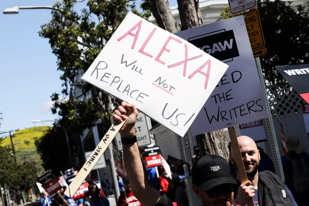 A placard from the 2023 Writer's Strike reading Alexa will not replace us!