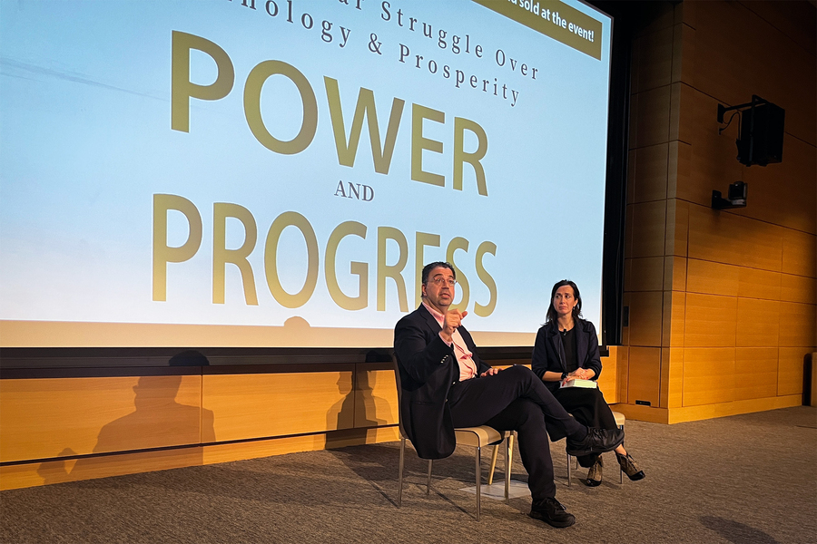Daron Acemoglu and Fotini Christia on stage in front of projected screen that says“Power and Progress”.