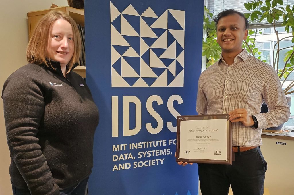 Noelle Selin awards Arnab Sarker in front of an IDSS banner