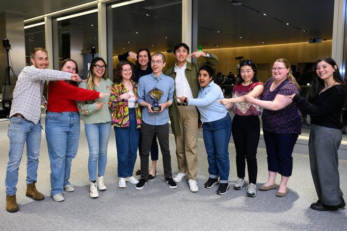 Christopher Maynard poses with award, surrounded by friends