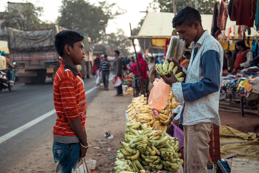 Two children talking at a market in India