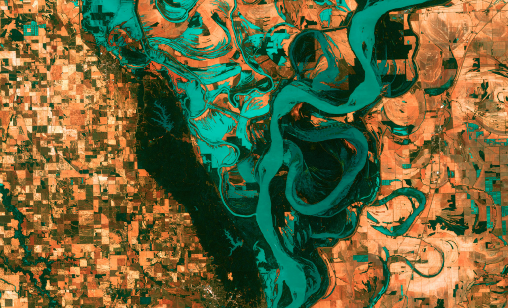 A satellite view of a large river delta surrounded by land